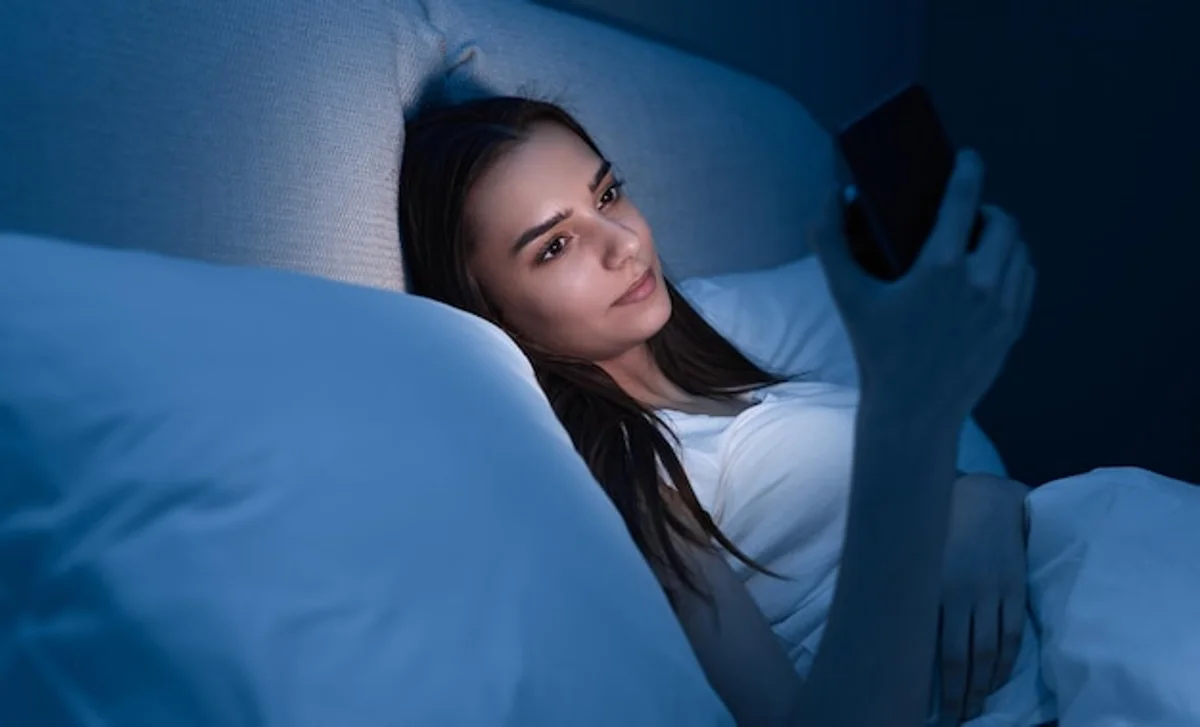 woman using sleep tracking app bed smartphone modern