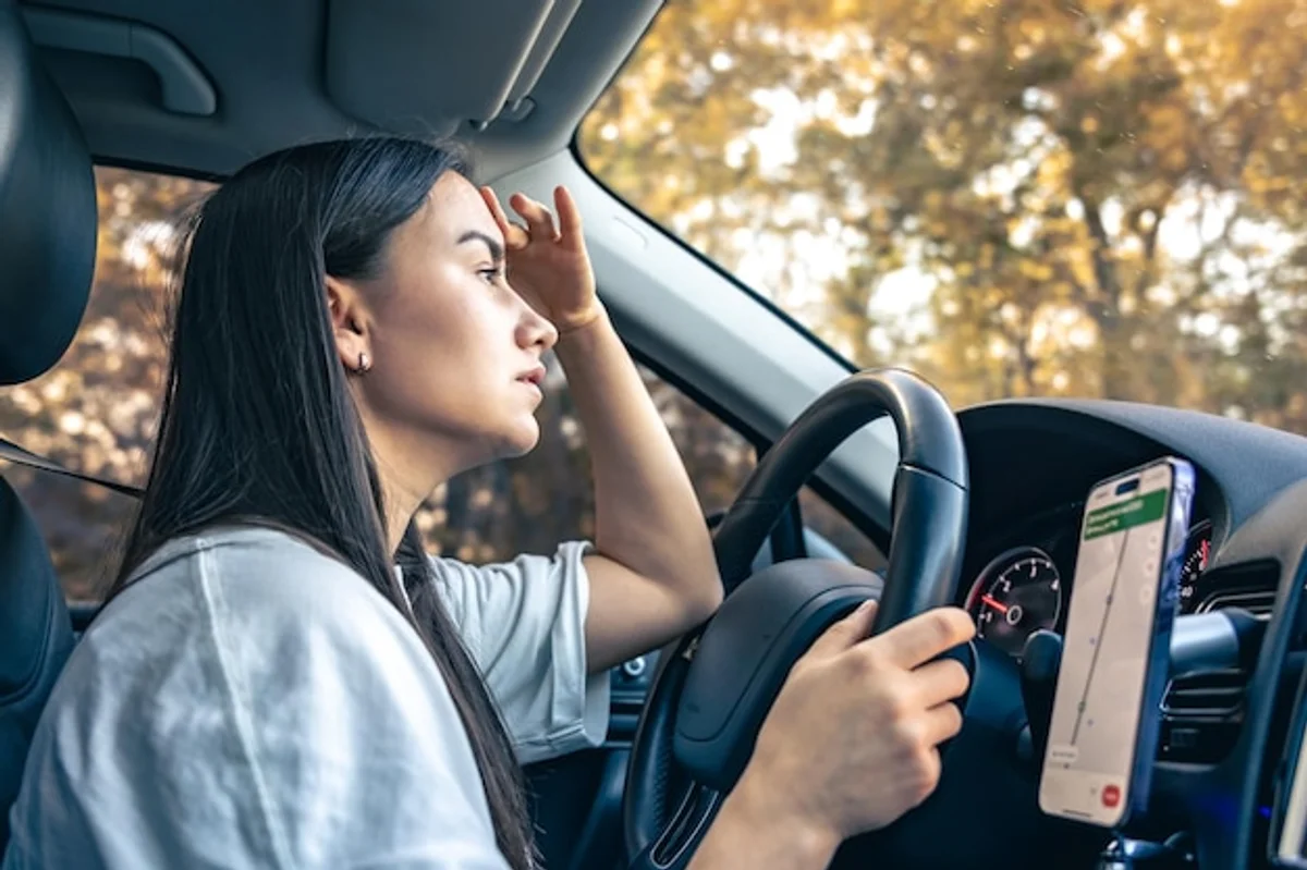 driver distracted by smartphone while driving in fog
