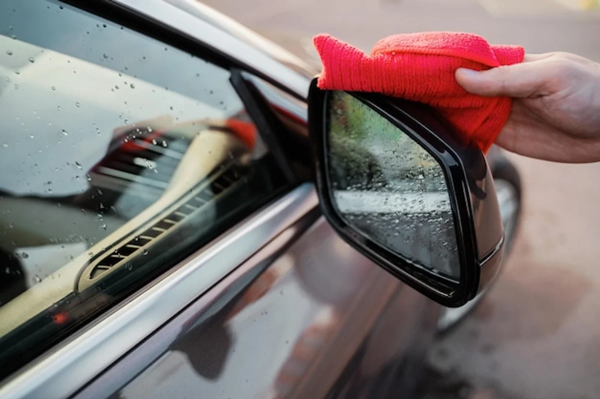hand replacing car windshield wiper autumn garage