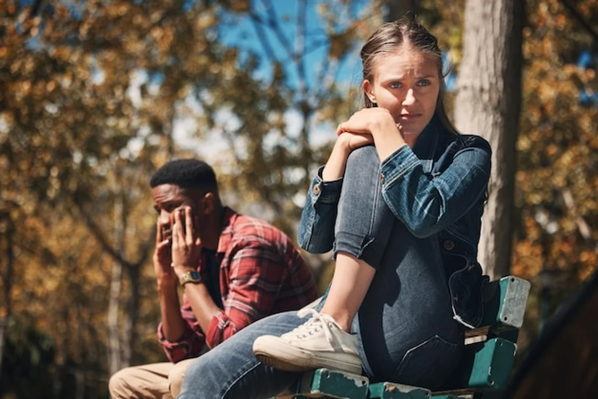 man and woman taking a break after argument in autumn park