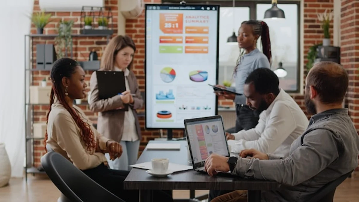 diverse professional people analyzing investment charts, laptop, friendly discussion