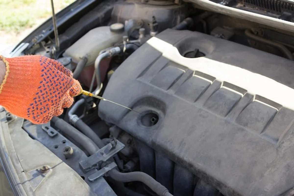 checking car oil in engine compartment