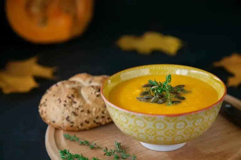 pumpkin soup with seeds and autumn vegetables close up