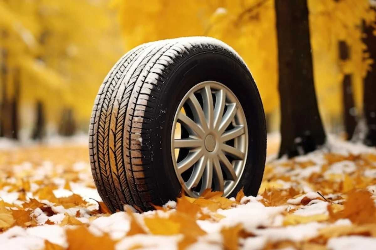 changing tire in autumn on snowy background