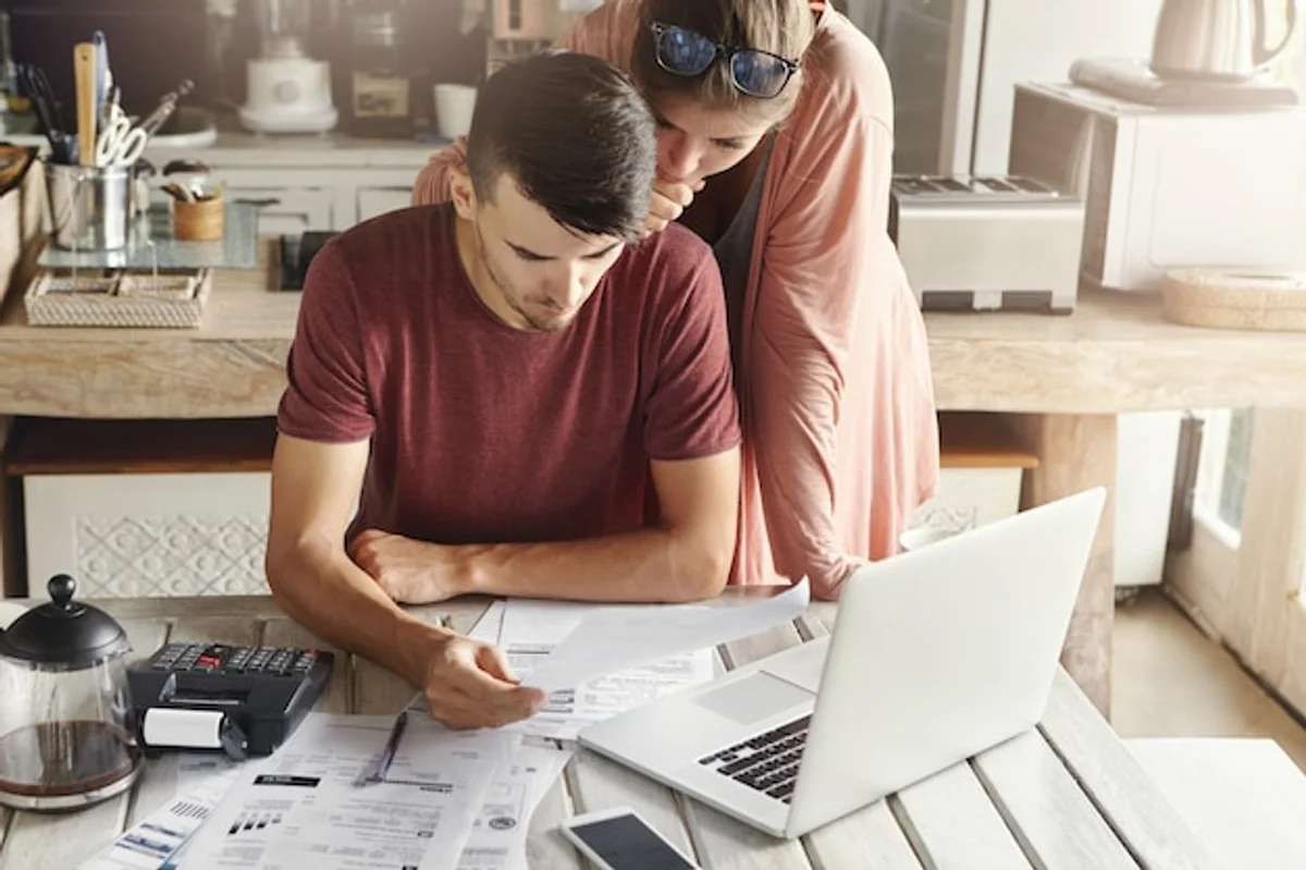 young family calculating finances with laptop