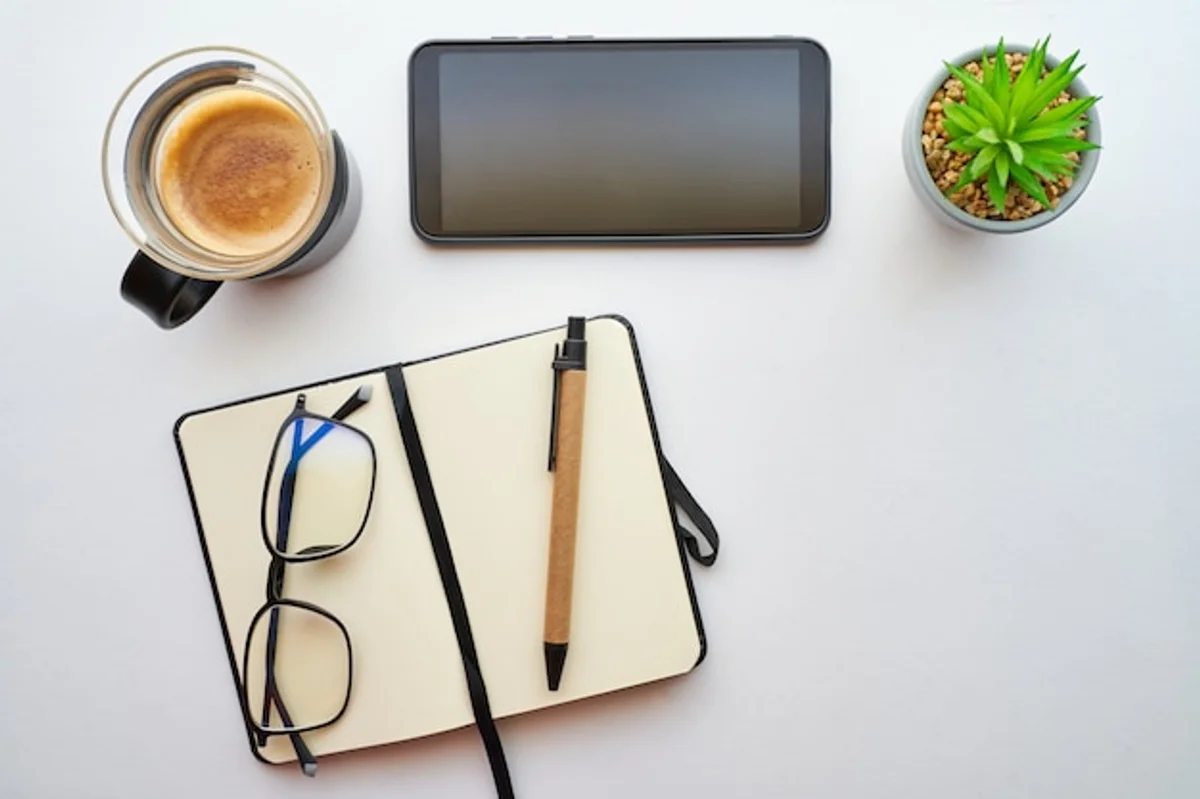 mobile productivity apps on desk with coffee and notebook