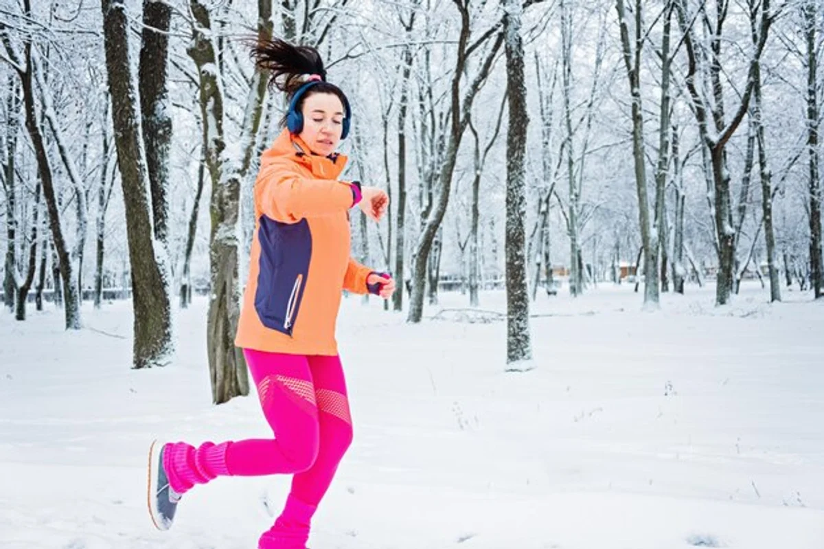 woman using smartwatch in winter with snow health tracking