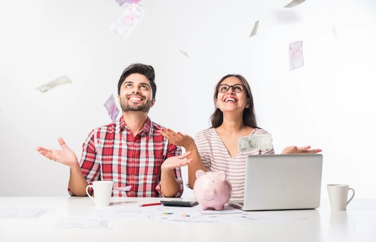 happy young couple planning future finances with calculator
