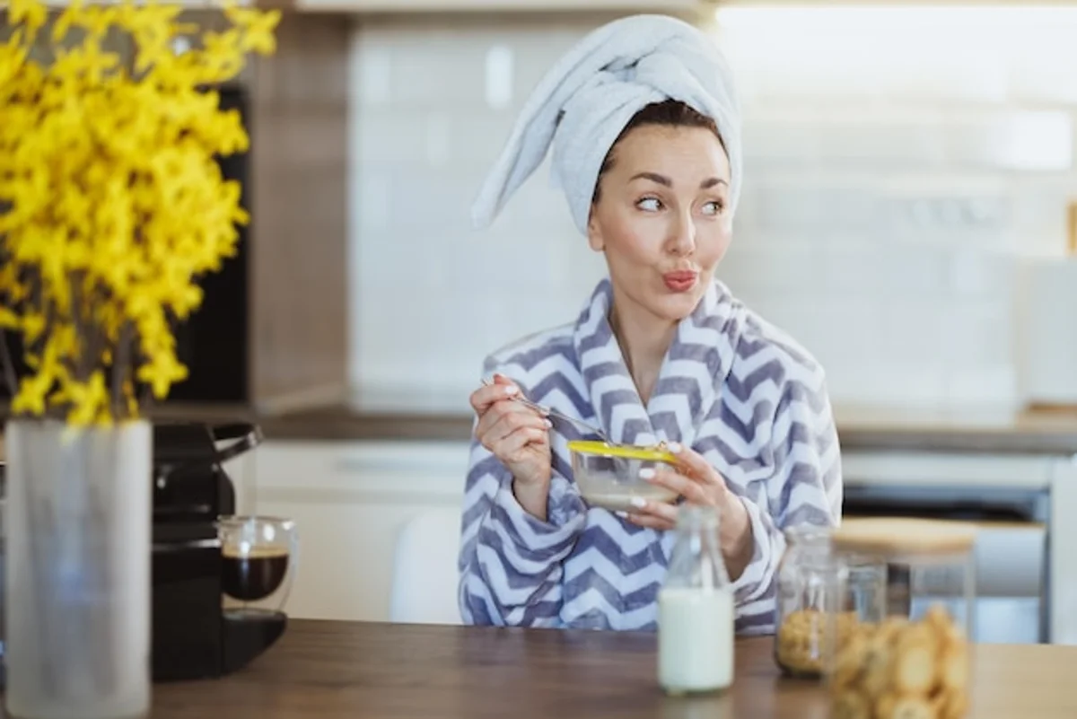 relaxed woman applying natural face mask in kitchen
