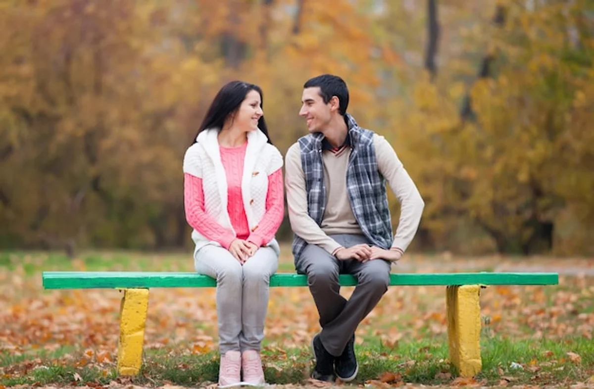 Sad couple sitting apart autumn park argument sadness