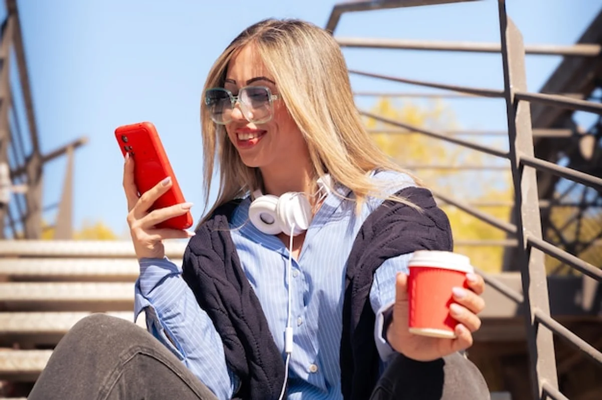 close up hand holding smartphone thermal case autumn street