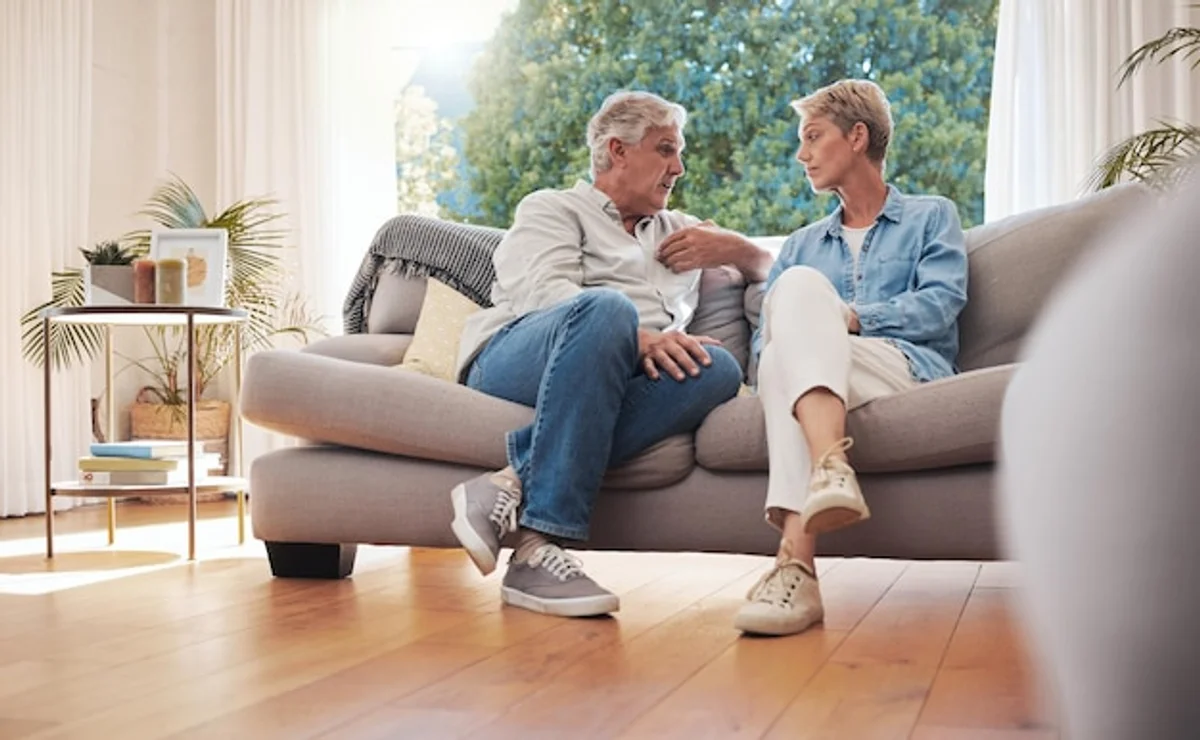 man and woman talking seriously on a couch