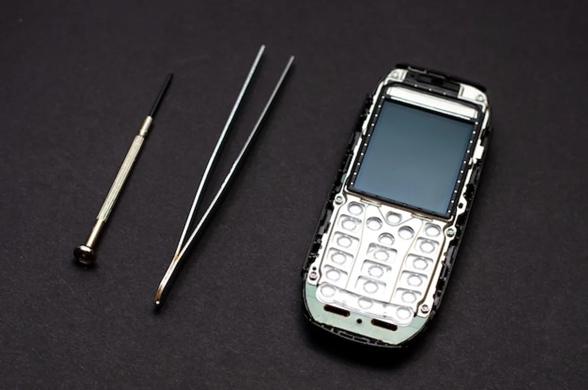 modern iPhone on table with hands pressing buttons for reset